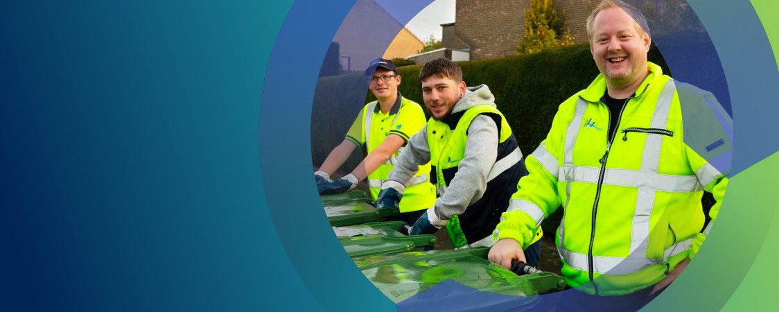 Drie lachende inzamelmedewerkers staan op een rij met minicontainers.