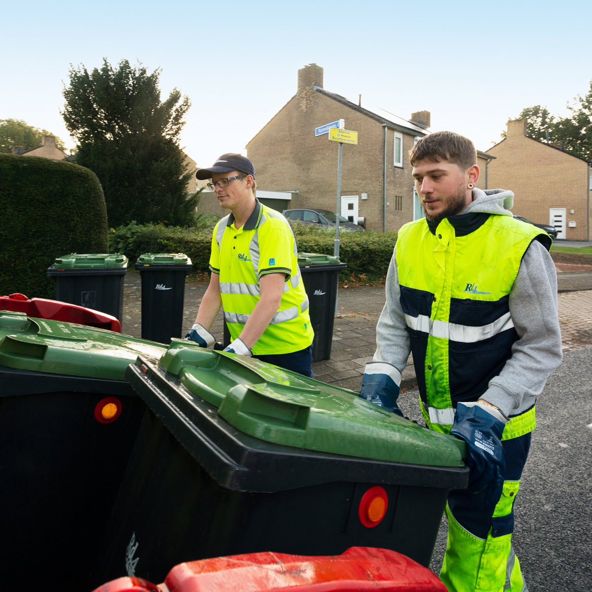 Twee inzamelmedewerkers legen GFT-containers.